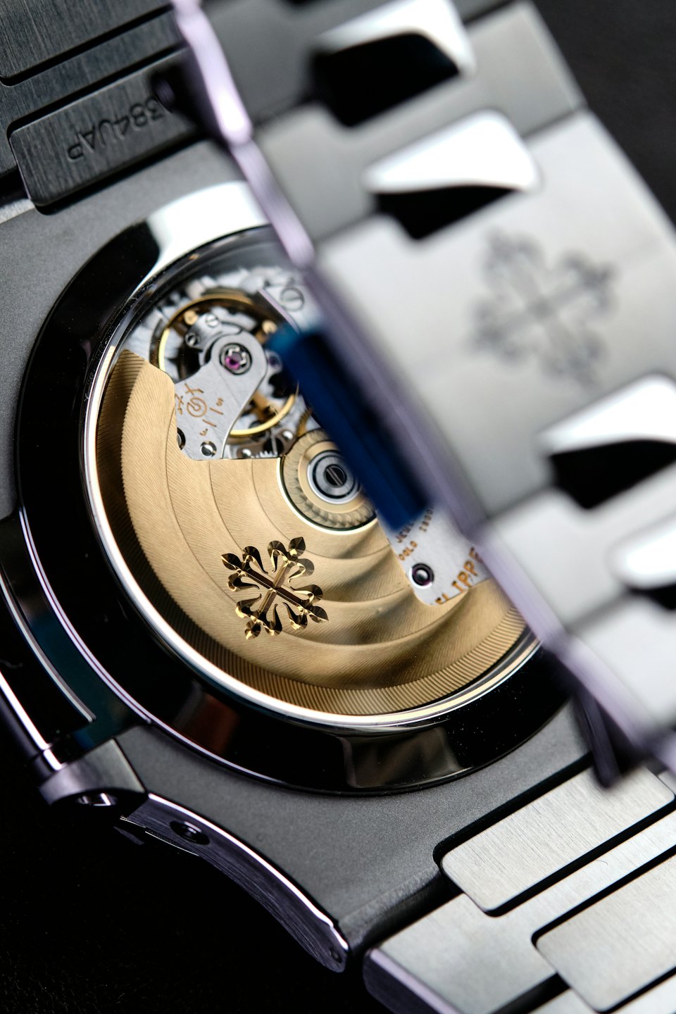 Intricate gears and jewels of a gold mechanical watch movement.